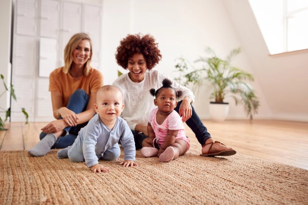 Two babies with adults looking after them